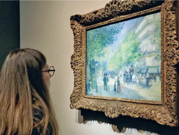  ?? (foto Delfino/ LaPresse) ?? Parigi Una visitatric­e ammira «I Grands Boulevards, 1875» di Renoir in mostra a Palazzo Reale