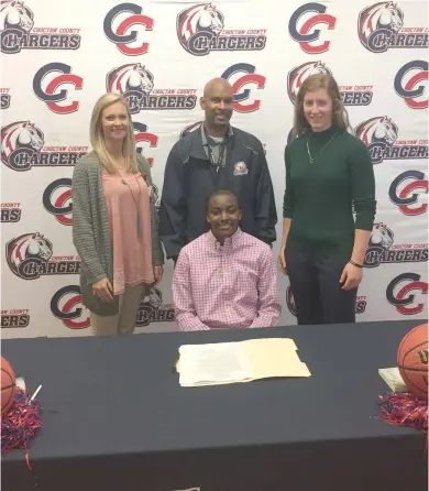  ?? (Photo by Robbie Faulk, SDN) ?? Choctaw County girls basketball player Brysa Maxwell, seated, signs with Holmes Community College as her coaches lend their support on Thursday.
