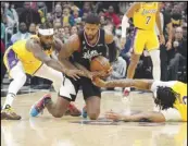  ?? Associated Press ?? Clippers guard Paul George (center) goes after a loose ball along with Lakers guard Patrick Beverley (left) and forward Anthony Davis during the first half on Wednesday in Los Angeles.