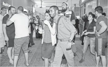  ??  ?? DUDU GRINSHPAN, AFP/GETTY IMAGES A woman is comforted Sunday at a bus station in the southern Israeli city of Beersheba where violence erupted and an innocent man was shot and attacked by a mob.