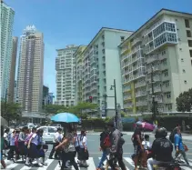  ??  ?? PEOPLE cross a pedestrian lane at Bonifacio Global City in Taguig. The Duterte government wants to bring down the unemployme­nt rate to 4% by 2022.