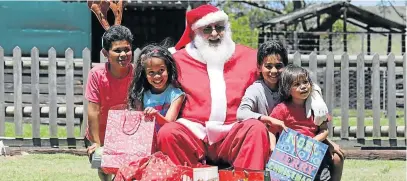  ?? Picture: FREDLIN ADRIAAN ?? FESTIVE FUN: Father Christmas (Derick Miles) hands out gifts to children, from left, Ethan Kops, 10, Cicely Thalla, 9, Sean Kops, 8, and Joshua Kops, 4, at Holmeleigh Farmyard