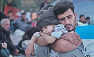  ?? THE CANADIAN PRESS ?? A Syrian refugee child sleeps on his father’s arms while waiting at a resting point to board a bus on the northeaste­rn Greek island of Lesbos last month. Cape Bretoners are getting ready to welcome some refugee families to the island.