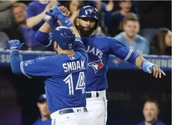  ?? STEVE RUSSELL/TORONTO STAR ?? Justin Smoak celebrates his two-run homer in the sixth with Jose Bautista at the Rogers Centre on Saturday.