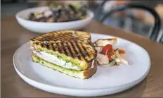  ?? Andrew Stein/Post-Gazette photos ?? A grilled parma cotta sandwich is made with sourdough bread, fresh mozzarella, basil pesto and arugula.