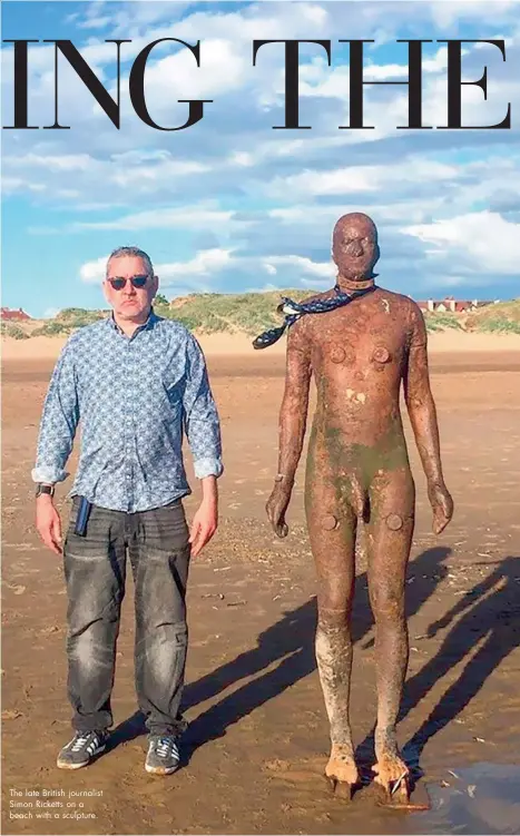  ??  ?? The late British journalist Simon Ricketts on a beach with a sculpture.