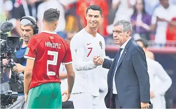  ?? — AFP photo ?? Portugal’s Cristiano Ronaldo (centre) shakes hands with coach Fernando Santos (right) next to Morocco’s Achraf Hakimi at the end of the match.