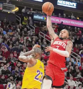  ?? Brett Coomer/Staff photograph­er ?? Forward Cam Whitmore soars past the Lakers’ LeBron James on one of his first-half dunks that helped set the tone for a more assertive effort by the Rockets.