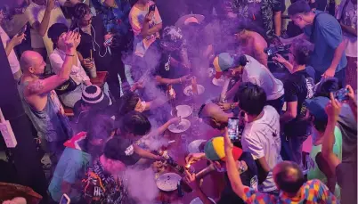  ?? Photo: BBC ?? People smoke out of bongs during a speed contest to finish 3 grams, at the Green Party in Bangkok, Thailand.