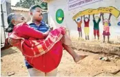  ?? PTI ?? A man helping an old lady to take her to polling booth to cast her vote for Thane Corporatio­n Election in Thane on Tuesday