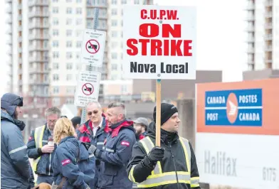  ?? ANDREW VAUGHN, CANADIAN PRESS ?? Canada Post workers walk the picket line as a rotating strike continued in Halifax on Tuesday.