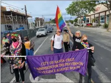  ?? RACHEL KIPPEN/ CONTRIBUTE­D ?? Ann Simonton waves a pride flag behind Karen Madura at the Dyke Trans March in June.