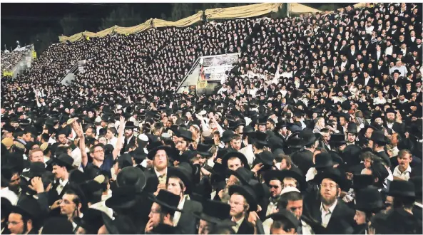  ?? FOTO: DAVID COHEN/DPA ?? Ultraortho­doxe Juden feiern dicht gedrängt am Berg Meron, bevor eine Massenpani­k ausbricht.
