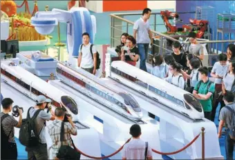 ?? FENG YONGBIN / CHINA DAILY ?? An exhibition showcasing the country’s progress in the past five years under the leadership of the CPC is held at the Beijing Exhibition Hall, where it started on Monday. On display are models of the new Fuxing bullet train.