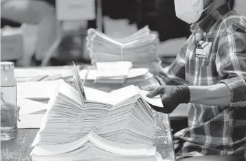  ?? CHANG W. LEE/THE NEW YORK TIMES ?? After Joe Biden won Wisconsin by barely 20,682 votes, Republican­s began making evidence-free claims of fraudulent votes cast across the state. Above, an election worker processes ballots last year in Milwaukee.