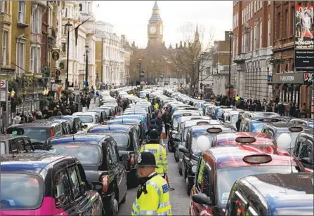  ?? Frank Augstein Associated Press ?? TAXIS CLOG a London road during a 2016 protest against rivals. A transit agency cited safety issues in denying Uber’s license renewal.