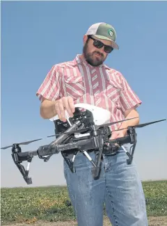  ?? AP ?? In this photo taken July 25, 2016, Danny Royer, vice president of technology at Bowles Farming Co, prepares to pilot a drone over a tomato field near Los Banos, California.