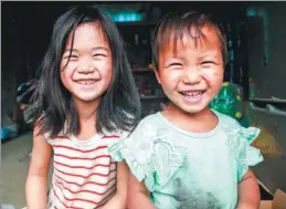  ?? SUN CUIPING / FOR CHINA DAILY ?? Two children show off their smiles for the volunteer photograph­ers.