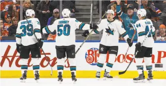  ?? Jason Franson / Associated Press ?? The Sharks’ Tomas Hertl (second from right) celebrates his overtime goal with teammates Logan Couture, Chris Tierney and Marc-Edouard Vlasic in a 4-3 victory at Edmonton.