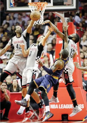  ??  ?? Cleveland Cavaliers’ Kyrie Irving (2) shoots as Houston Rockets’ Nene Hilario (42), Ryan Anderson (3) and James Harden (13) defend during the second half of an NBA basketball game in Houston on Sunday night. (AP)