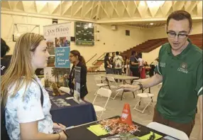  ??  ?? Brenna Stewert (left), Holtville High School junior at Imperial County Office of Education College Fair in the school gym Thursday. WILLIAM ROLLER PHOTO