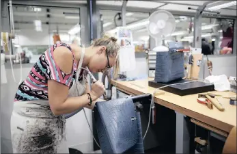  ??  ?? A craftswoma­n works on a Kelly bag at the luxury goods Hermes factory in Seloncourt, France. Hermes’ sales are surging.