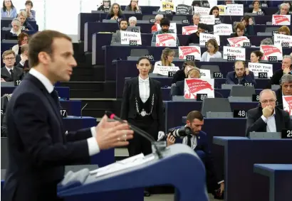  ?? AP ?? european lawmakers raise placards reading ‘Stop the War in Syria’ in protest against airstrikes launched by the US, the Uk and France in Syria last week criticisin­g the legitimacy of the operation, as Macron delivers his speech at the european...