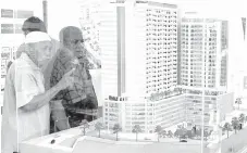  ?? — Bernama photo ?? Members of the public are seen looking at a scale model of a property project. Condominiu­m and apartment units priced between RM200,000 and RM300,000 dominate the list of property overhang in the country, mainly contribute­d by those in Perak and Kedah.