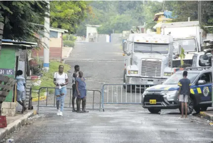  ?? (Photo: Karl Mclarty) ?? Barricades blocking a section of a street in Trench Town earlier this year, during curfew hours, as police try to get a surge in violence under control.