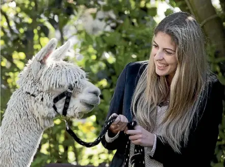  ??  ?? Left: Reporter Kelley Tantau tries to charm alpaca, Santa.