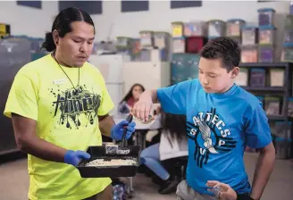  ?? ROBERTO E. ROSALES/JOURNAL ?? Staff member Anthony Shemayme serves cornbread to South Valley Prep student Andre Guerrero. Shemayme says the lessons kids get on their weekly trips to a farm help hone their work ethic.