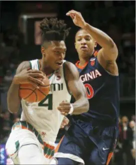  ?? WILFREDO LEE — THE ASSOCIATED PRESS ?? Miami’s Lonnie Walker IV (4) drives to the basket against Virginia’s Devon Hall (0) during the first half Tuesday in Coral Gables, Fla.