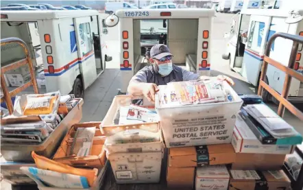  ?? ADAM CAIRNS/COLUMBUS DISPATCH ?? Postal worker Tony Sobony, 43, loads his delivery truck with mail and packages on the loading dock behind the South Columbus branch of the United States Postal Service. A mail carrier for 21 years, Sobony said there’s nothing he’d rather do despite the COVID-19 pandemic and other challenges of the past year.