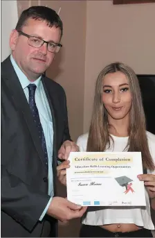  ??  ?? Saoirse Meenan accepts her certificat­e from Paul Rosbotham of the LMETB at the ceremony in Boomerang Cafe.