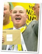  ?? ?? TRUE COLOURS: Mr Hanvey wore a yellow rosette – like the SNP’s – as he celebrated on election night