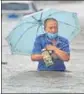  ?? REUTERS ?? A resident wades through floodwater­s on a road in Zhengzhou, China.