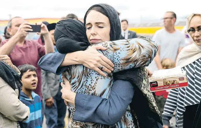  ?? HAGEN HOPKINS / GETTY ?? La primera ministra de Nueva Zelanda, Jacinda Ardern, abraza a una mujer musulmana en la mezquita de Kilbirnie, en la capital, Wellington