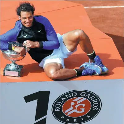  ?? PETR DAVID JOSEK / AP ?? Rafael Nadal poses with the French Open trophy after cruising to a 6-2, 6-3, 6-1 victory over Stan Wawrinka in Sunday’s final in Paris. It was the 31-year-old Spaniard’s 10th Roland Garros title and his 15th Grand Slam triumph.