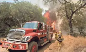  ?? AP ?? Firefighte­rs battle a wildfire near Oroville, Calif., on Saturday. The California Department of Forestry and Fire Protection reported several residents and one firefighte­r had minor injuries.