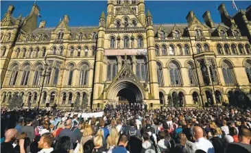  ?? BEN STANSALL/AGENCE FRANCE-PRESSE VIA GETTY IMAGES ?? People attend a vigil in Tuesday in Albert Square in Manchester, England, in solidarity with those killed and injured in Monday’s bombing. 22-year-old U.K. citizen Salman Abedi has been identified as the attacker.