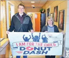  ?? STACI VANDAGRIFF/THREE RIVERS EDITION ?? Parker Samuel, left, and Laura Burks hold a banner advertisin­g the upcoming Donut Dash for Court Appointed Special Advocates of White County. The Donut Dash will be March 2 at Bison Park at Harding University in Searcy.