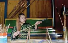  ??  ?? A Bhutanese shopkeeper displays arrows at a traditiona­l archery crafts stall at Norzin Lam in Thimphu.