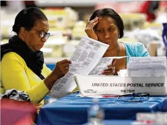  ?? CURTIS COMPTON / CCOMPTON@AJC.COM ?? Workers count votes Friday, going over ballots at the Fulton County Election Preparatio­n Center. Stacey Abrams is hoping to force a run-off for governor against Brian Kemp.