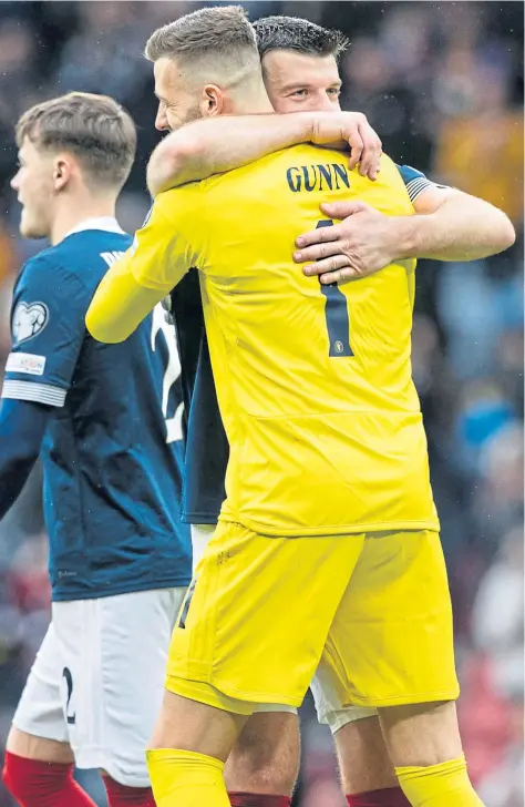  ?? ?? Angus Gunn embraces Norwich City team-mate, Grant Hanley, after they had combined to keep a clean sheet