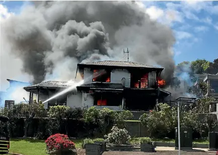  ?? SUPPLIED ?? Firefighte­rs attempt to hose down a house on fire in Taupo¯ .