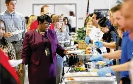  ?? BOB ANDRES / ROBERT.ANDRES@AJC.COM ?? Gwinnett County Public Schools’ central office staff pass through the food line to sample items from the school lunch menu, served Thursday at their workplace in the annual “Taste of Café Gwinnett” event.