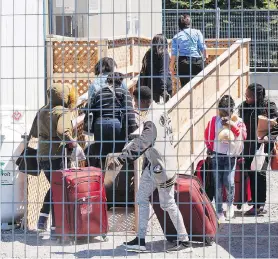  ?? RYAN REMIORZ/THE CANADIAN PRESS FILES ?? A group of asylum seekers arrive at the temporary housing facilities at a border crossing in St. Bernard-de-Lacolle, Que. Ninety-six per cent of irregular border crossers from the U.S. have been entering through Quebec.