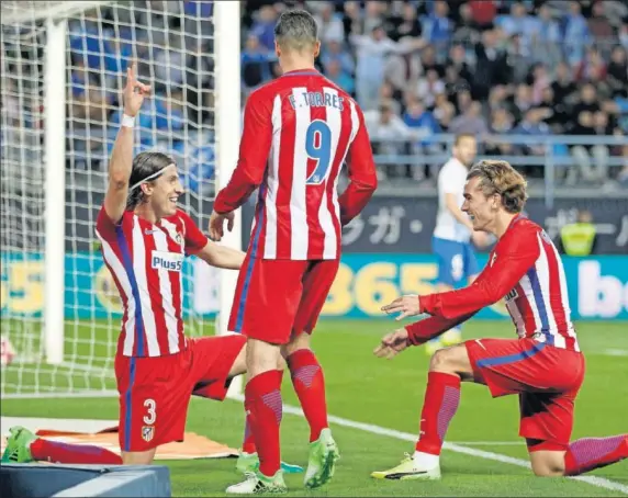  ??  ?? ALEGRÍA. Filipe Luis y Griezmann festejan el gol del primero en Málaga en presencia de Fernando Torres.