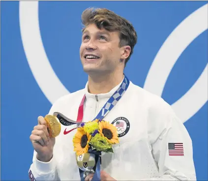  ?? MARTIN MEISSNER — THE ASSOCIATED PRESS ?? Bobby Finke of the U.S., who was fourth at the final turn, poses with the gold medal he received after winning the men’s 800-meter freestyle.