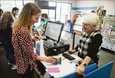  ?? Chris Carlson / Associated Press ?? Jessi Stout, owner of the Table Rock Pharmacy helps Debra Bowles on Friday in Morganton, N.C. Drugstore chains are still trying to find enough employees to halt temporary pharmacy closures.